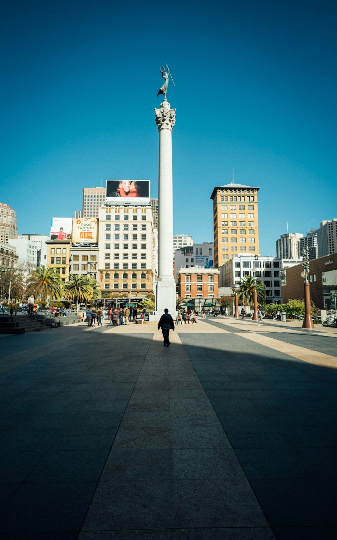 Documentary photo of a public plaza in a Chilean city with people sitting and walking