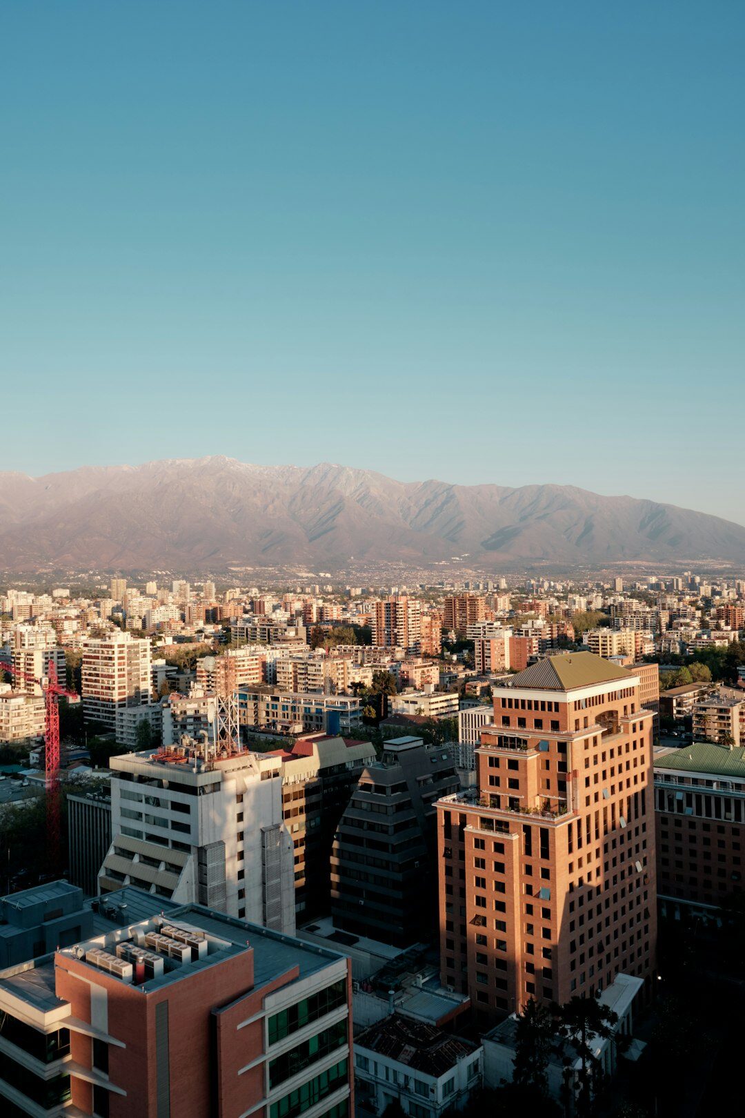 Rooftop view of Santiago Chile with the Andes mountains visible in the distance at sunset
